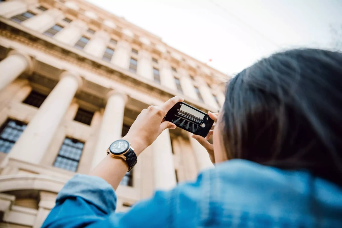 Touriste prenant une photo dโun bรขtiment.